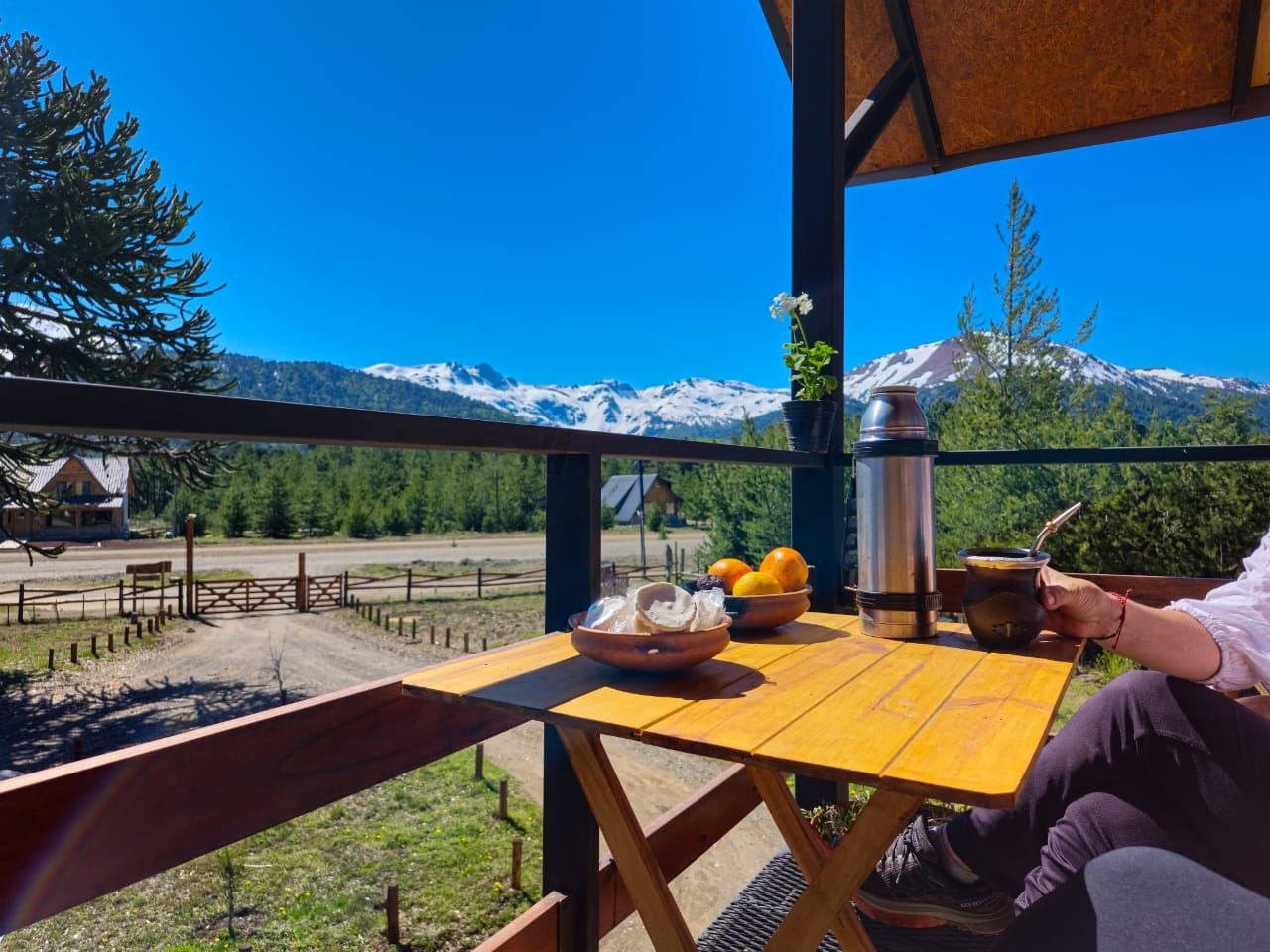 Mate y desayuno servidos en el balcón, con la cordillera de fondo